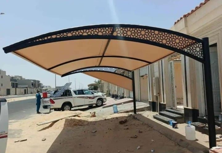 وحدة تلفزيون بيضاء بخلفية رخامية وأعمدة خشبية مضلّعة ورفوف عرض